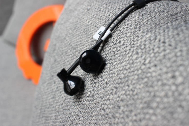 Xiaomi Bluetooth Half In-Ears liegen auf grauen Kissen.